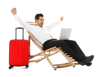 Photo of Young businessman with laptop and suitcase on sun lounger against white background. Beach accessories