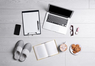 Flat lay composition with business supplies and home accessories on white wooden floor. Concept of balance between work and life