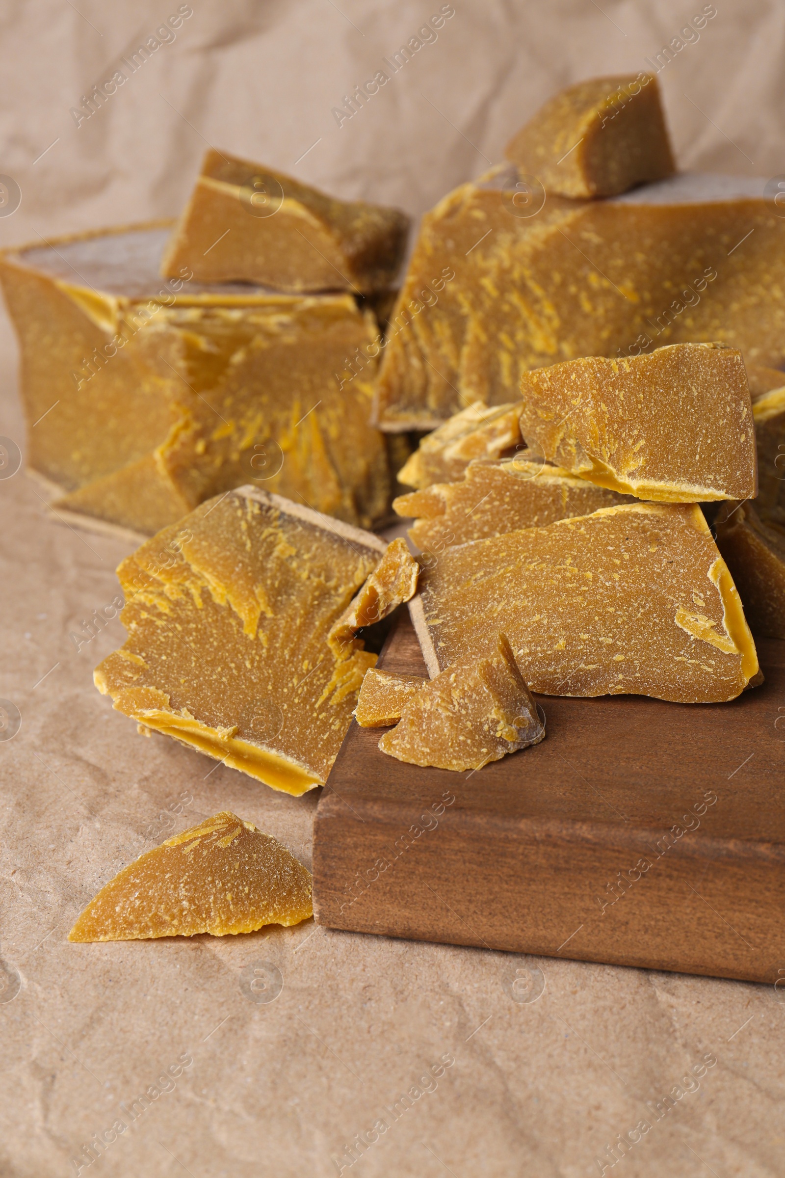 Photo of Natural organic beeswax blocks on parchment paper, closeup