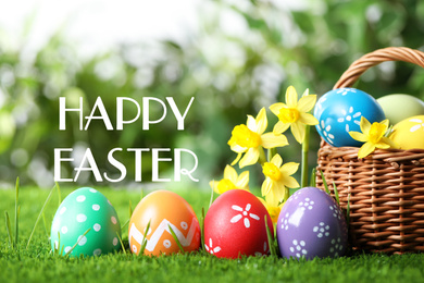 Image of Colorful eggs with daffodil flowers and text Happy Easter on blurred background