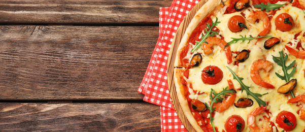 Image of Top view of hot delicious pizza on wooden table, space for text. Banner design 