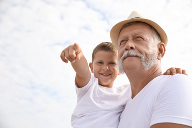 Photo of Grandfather with little boy outdoors in summer