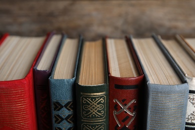 Stack of hardcover books on wooden background, closeup