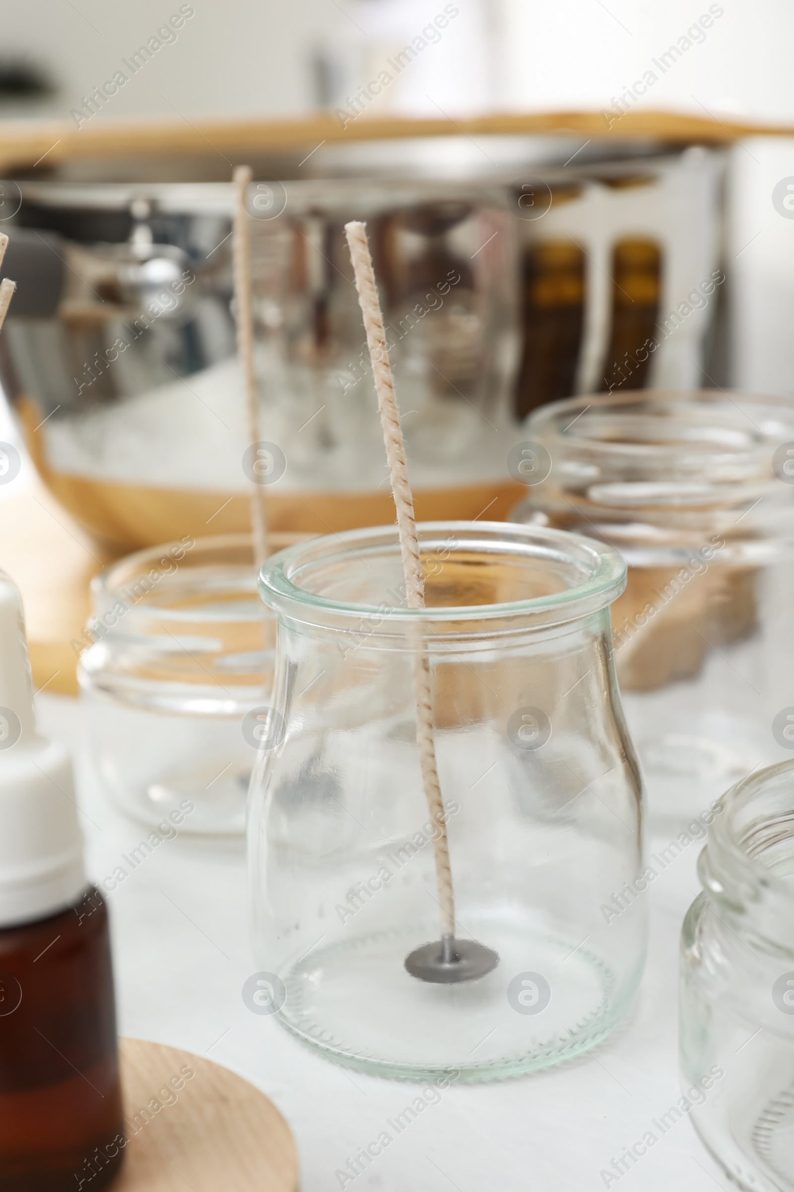 Photo of Glass jar with wick on white kitchen table. Making homemade candle