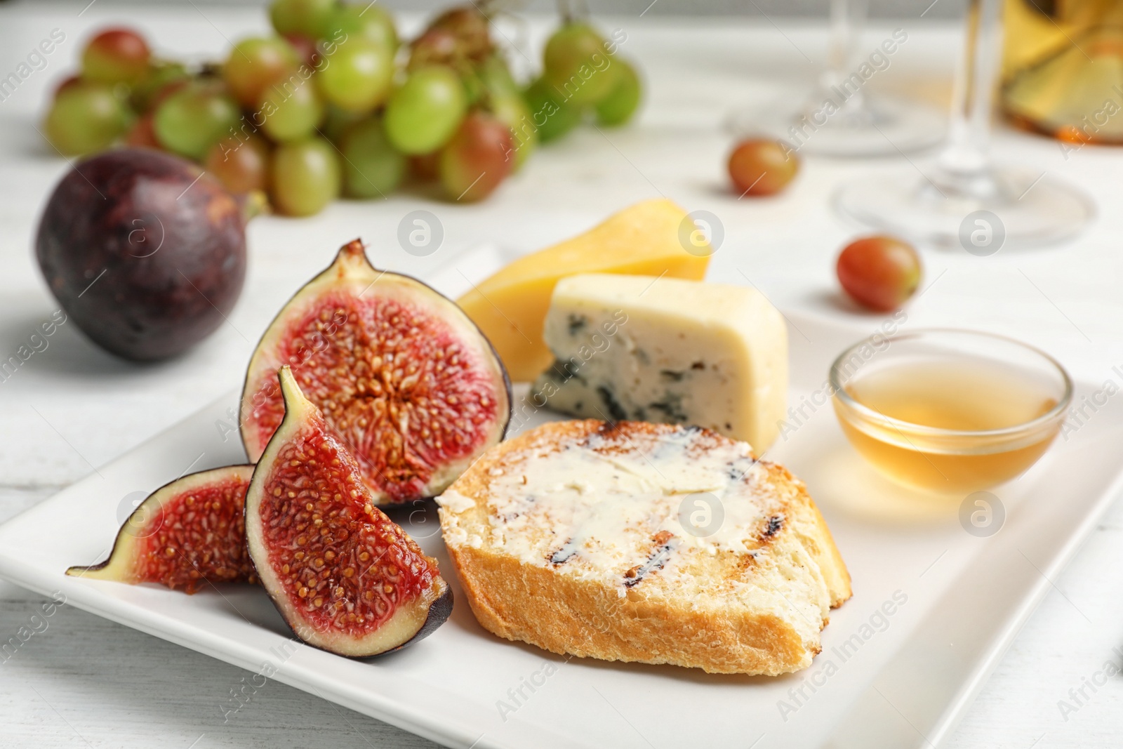 Photo of Ripe figs and slice of bread with butter on plate