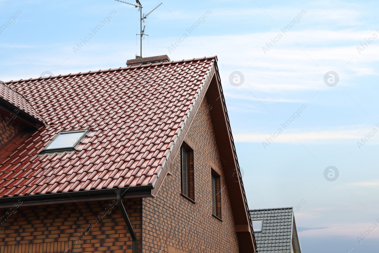 Photo of Beautiful house with red roof against blue sky