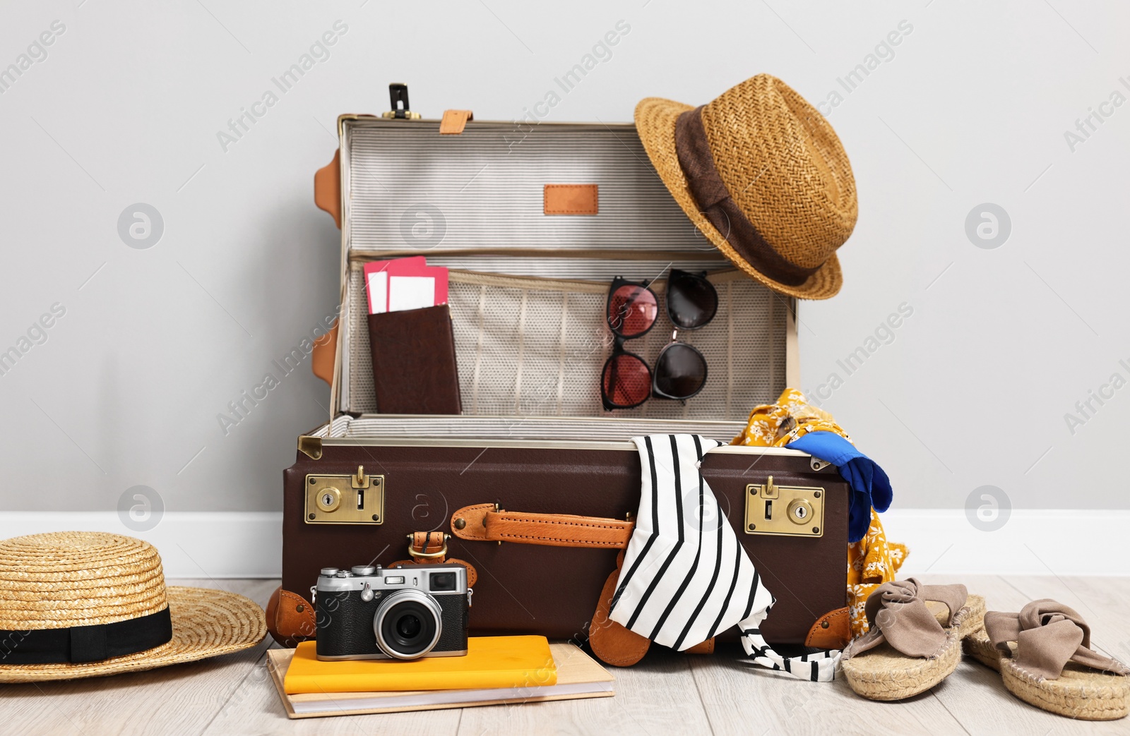 Photo of Clothes, camera and suitcase indoors. Prepare for travel