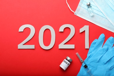 Photo of Flat lay composition with coronavirus vaccine and number 2021 on red background