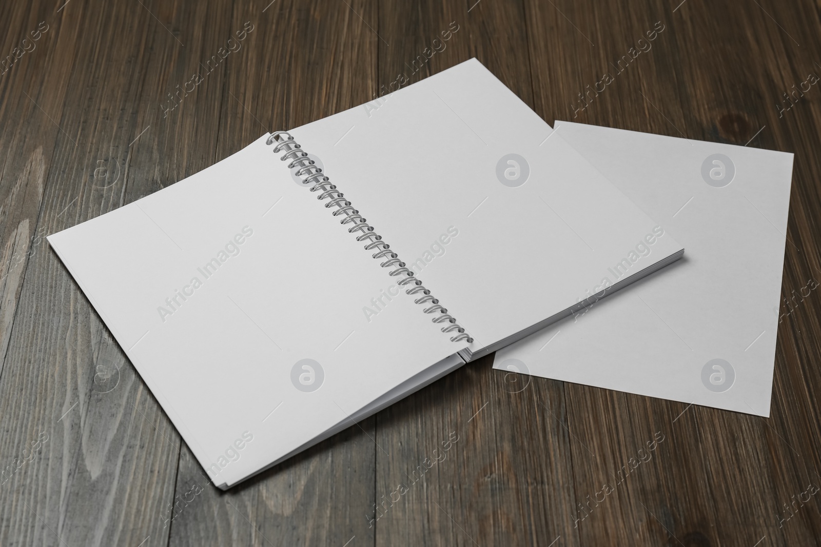 Photo of Sheet of paper and blank brochure on wooden table. Mockup for design