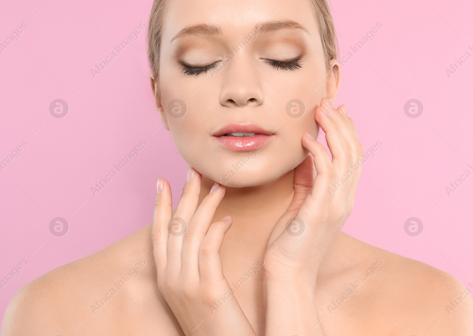 Photo of Portrait of young woman with beautiful face on pink background, closeup