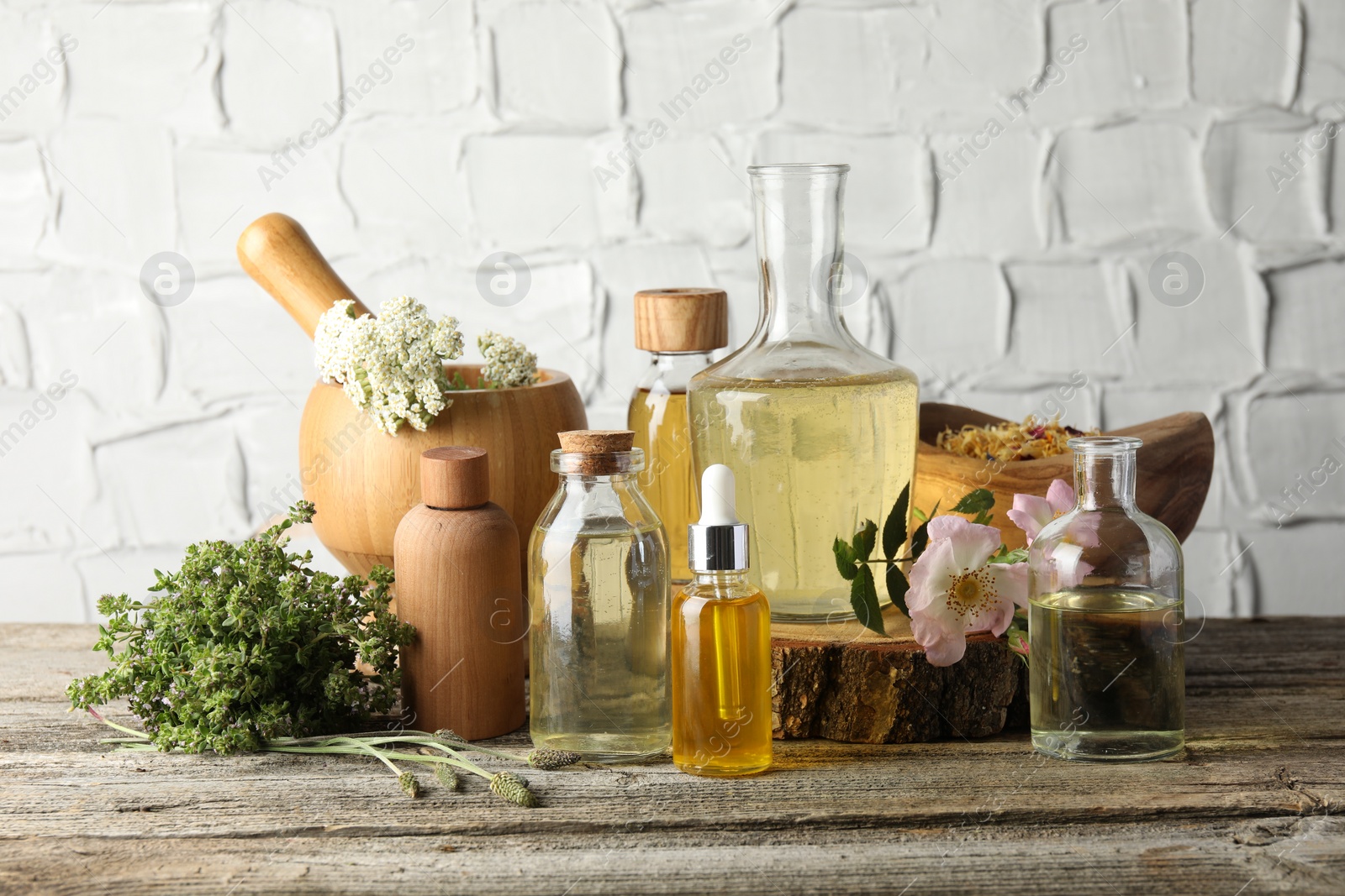 Photo of Aromatherapy. Different essential oils, herbs and flowers on wooden table