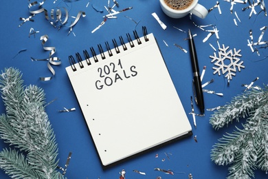 Photo of Inscription 2021 Goals in notebook, new year aims. Objects on blue background, flat lay