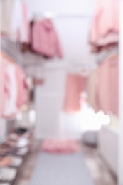 Blurred view of modern dressing room with different stylish clothes and accessories