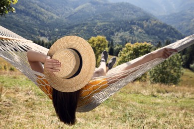 Young woman resting in hammock outdoors on sunny day