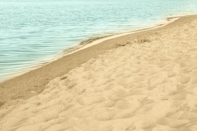 Photo of View of sea water and beach sand on sunny summer day