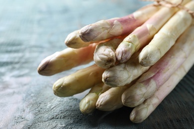 Photo of Bunch of fresh white asparagus on light blue wooden table, closeup