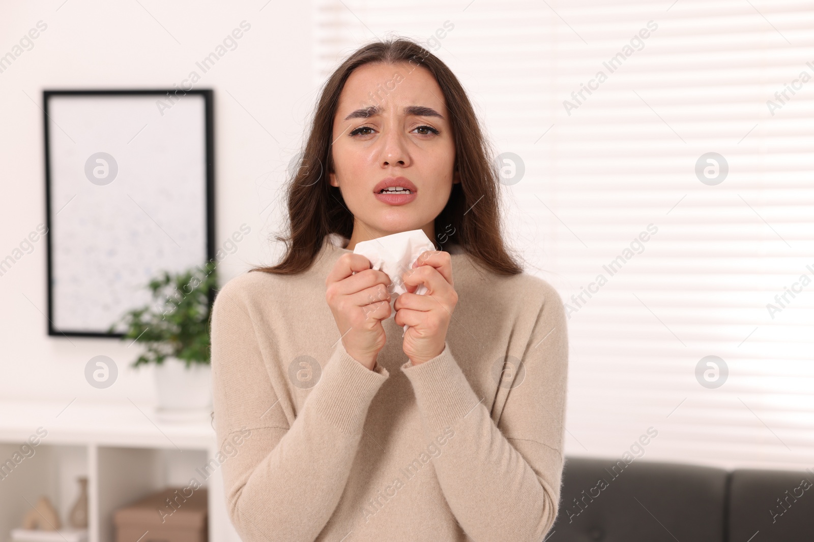 Photo of Sick woman with tissue at home. Cold symptoms