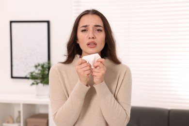 Sick woman with tissue at home. Cold symptoms