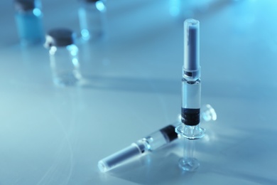 Photo of Syringes with COVID-19 vaccine on light table, space for text