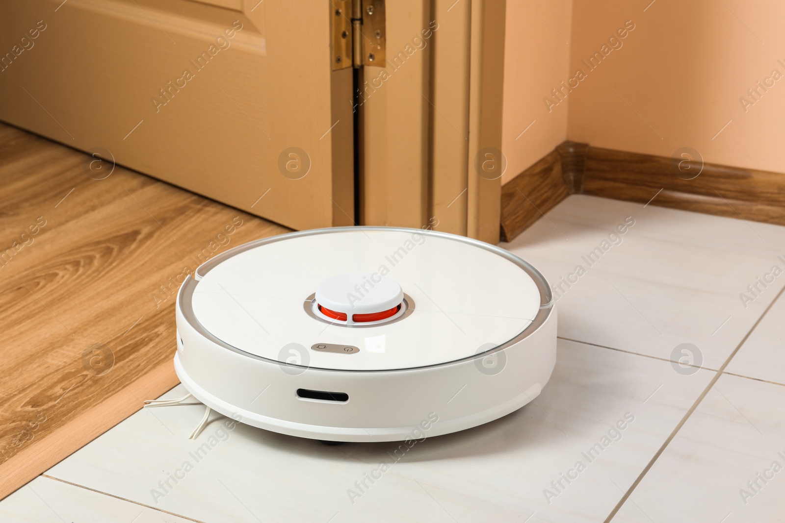 Photo of Modern robotic vacuum cleaner on white floor indoors