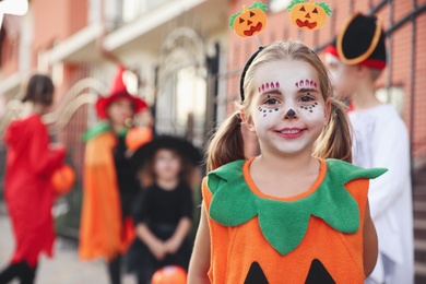 Cute little girl wearing Halloween costume outdoors