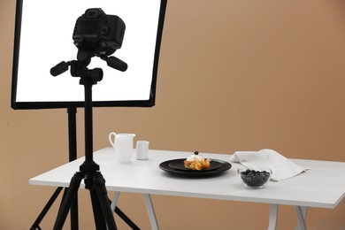 Photo of Professional equipment and composition with delicious dessert on white wooden table in studio. Food photography