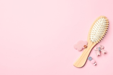 Photo of Flat lay composition with modern wooden hair brush on pink background. Space for text