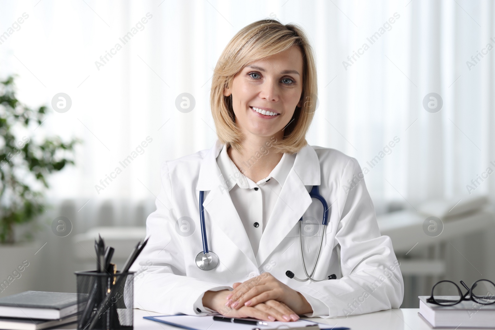 Photo of Portrait of smiling doctor at table in office