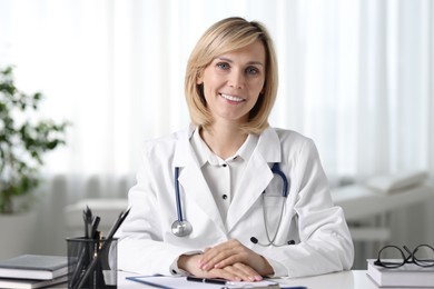 Portrait of smiling doctor at table in office