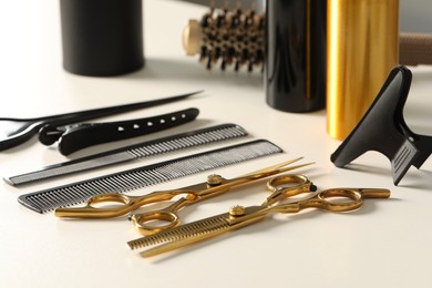 Hairdresser tools. Different scissors and combs on white table