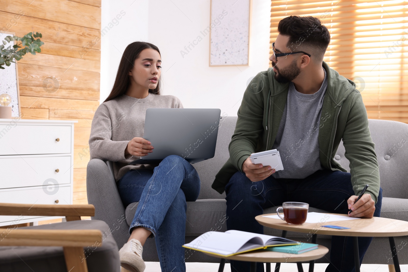 Photo of Young couple discussing family budget at home