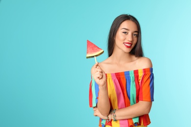 Photo of Beautiful young woman posing with watermelon on color background