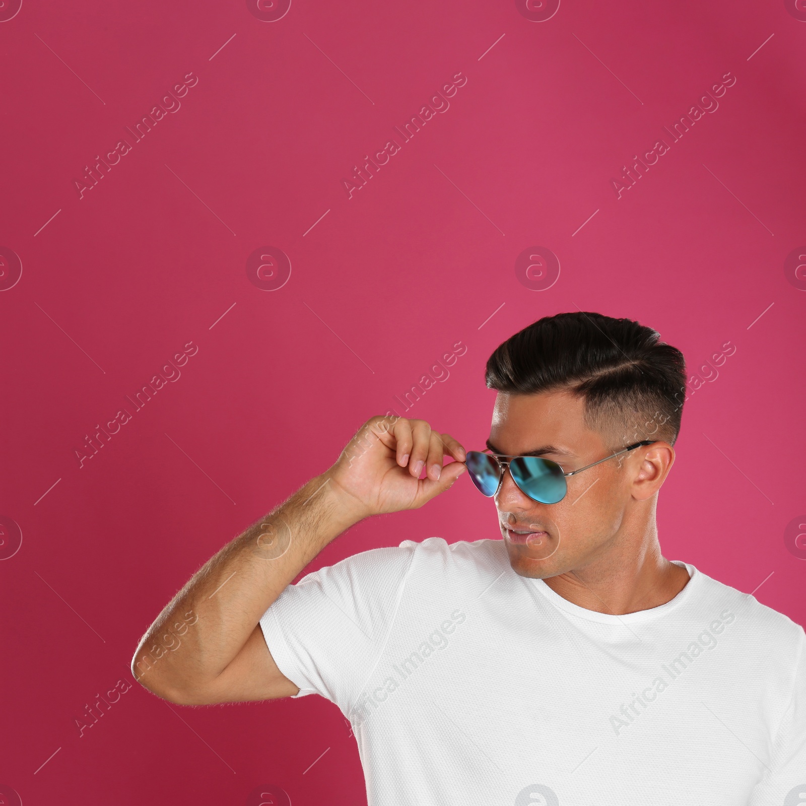 Photo of Handsome man wearing sunglasses on pink background