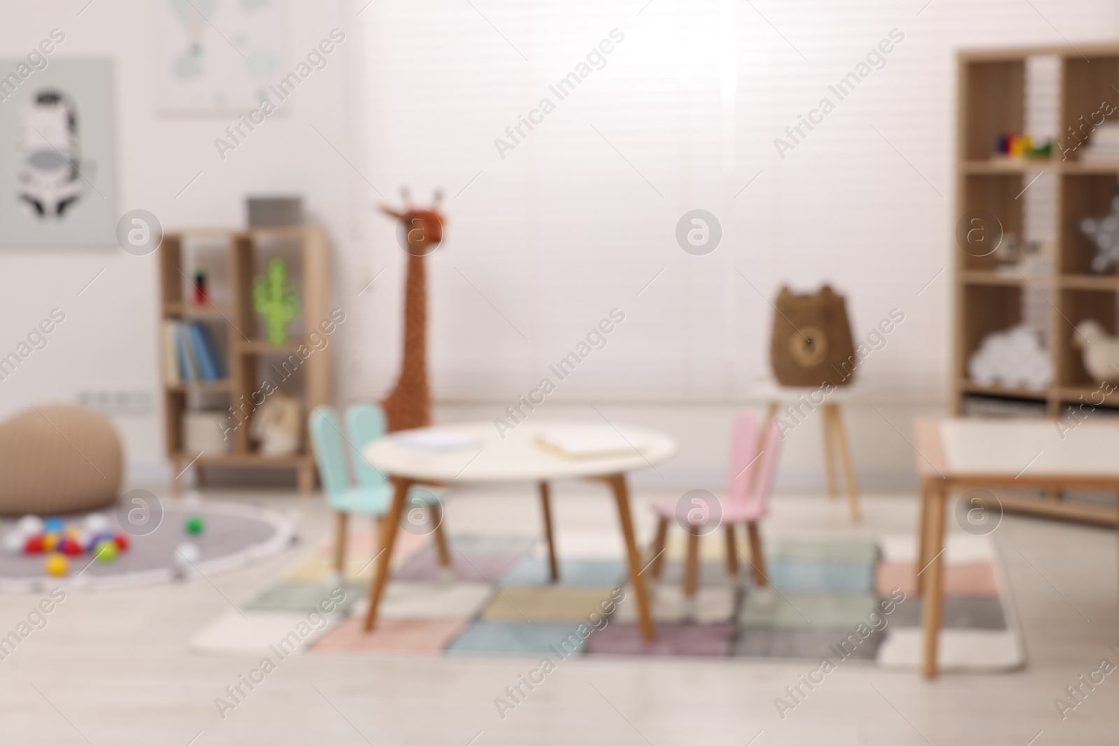 Photo of Stylish kindergarten interior with toys and modern furniture, blurred view