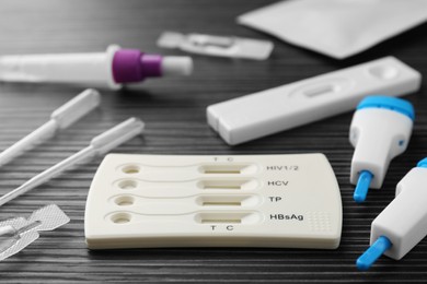 Photo of Disposable express test kits on black wooden table, closeup