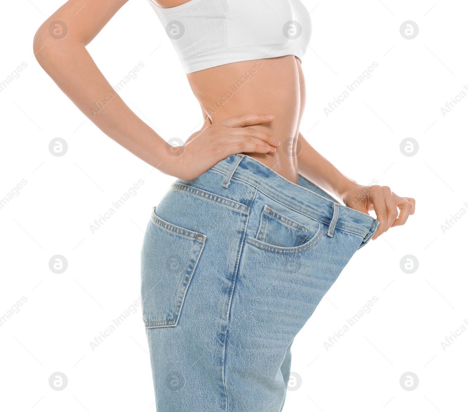 Photo of Slim young woman with smooth gentle skin in oversized jeans on white background, closeup. Beauty and body care concept