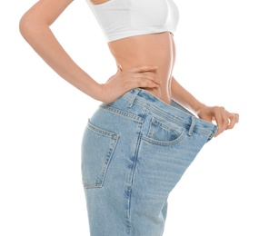 Photo of Slim young woman with smooth gentle skin in oversized jeans on white background, closeup. Beauty and body care concept