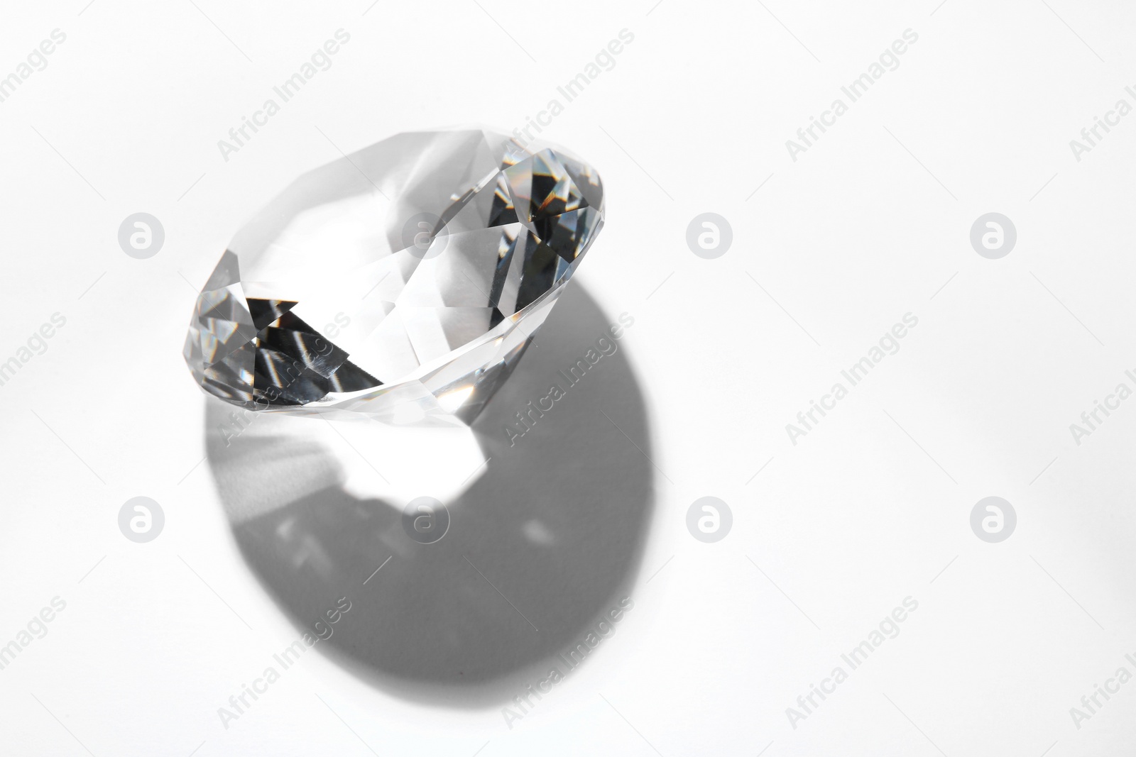 Photo of One beautiful shiny diamond on white background, space for text