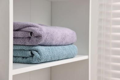 Stacked fesh towels on shelf indoors. Space for text