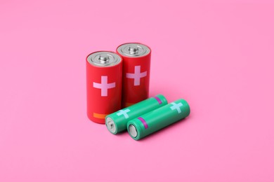 Photo of New AA and C sizes batteries on pink background