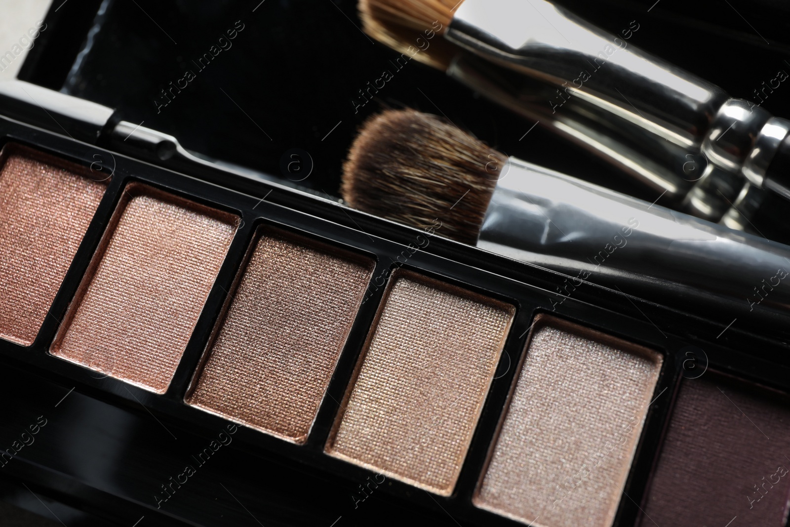 Photo of Beautiful eye shadow palette with brushes, closeup