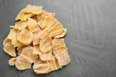 Delicious dried jackfruit slices on grey table, flat lay. Space for text