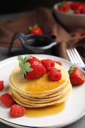 Photo of Tasty pancakes with fresh berries and honey on plate, closeup