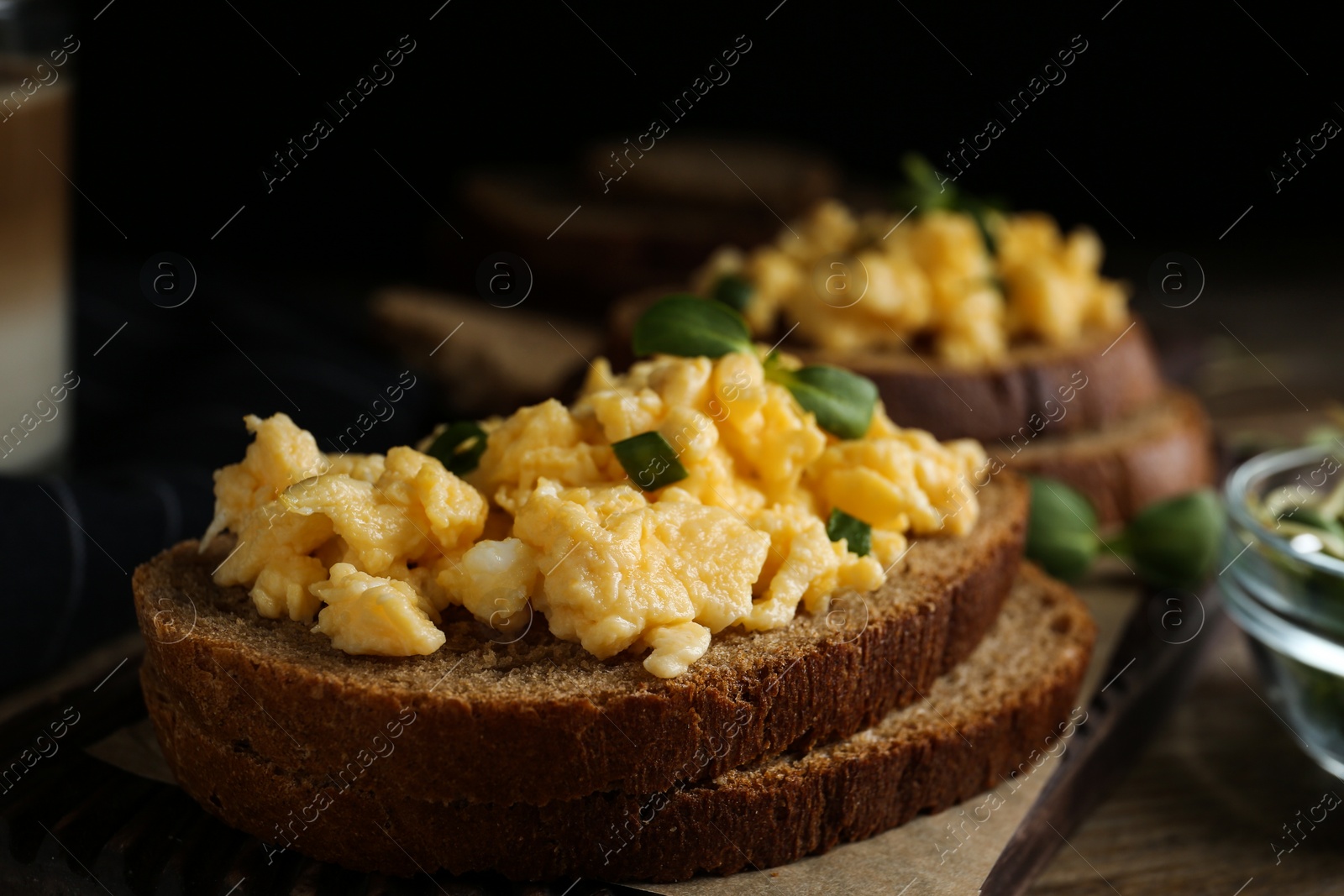 Photo of Tasty scrambled egg sandwich on table, closeup