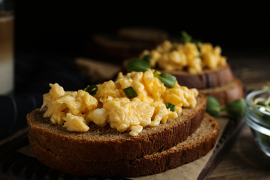 Tasty scrambled egg sandwich on table, closeup