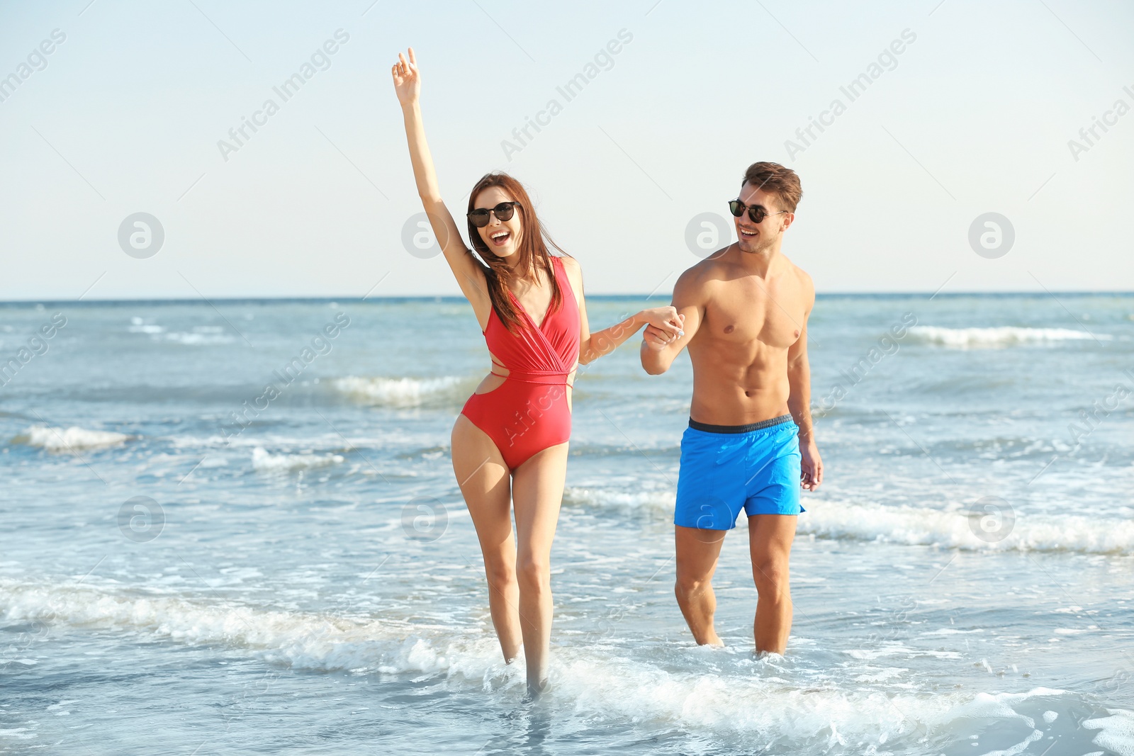 Photo of Happy young couple having fun at beach on sunny day