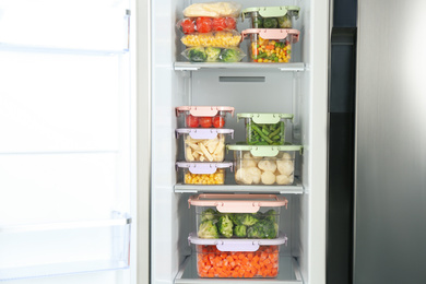 Containers with different frozen vegetables in refrigerator