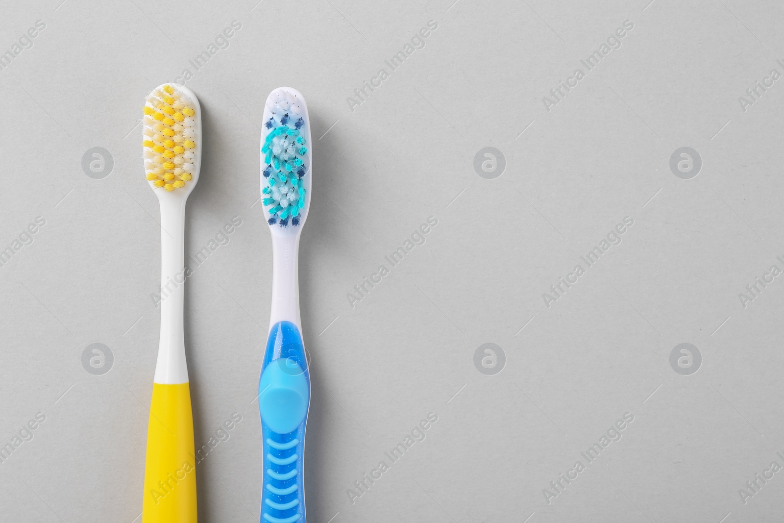 Photo of Different toothbrushes on light background, flat lay. Space for text