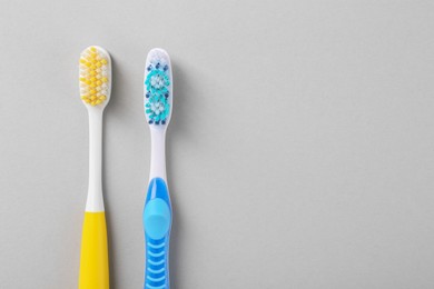 Different toothbrushes on light background, flat lay. Space for text