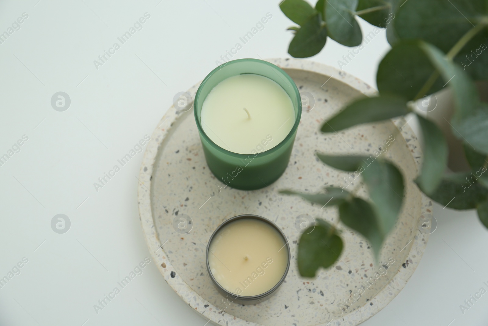 Photo of Candles and eucalyptus branches on white table, above view. Interior element